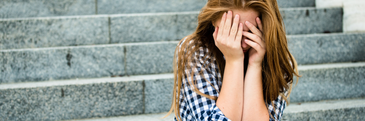 What It's Like to Grow Up With Depression and Not Understand It teenage girl with depression sitting on steps