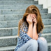 teenage girl with depression sitting on steps
