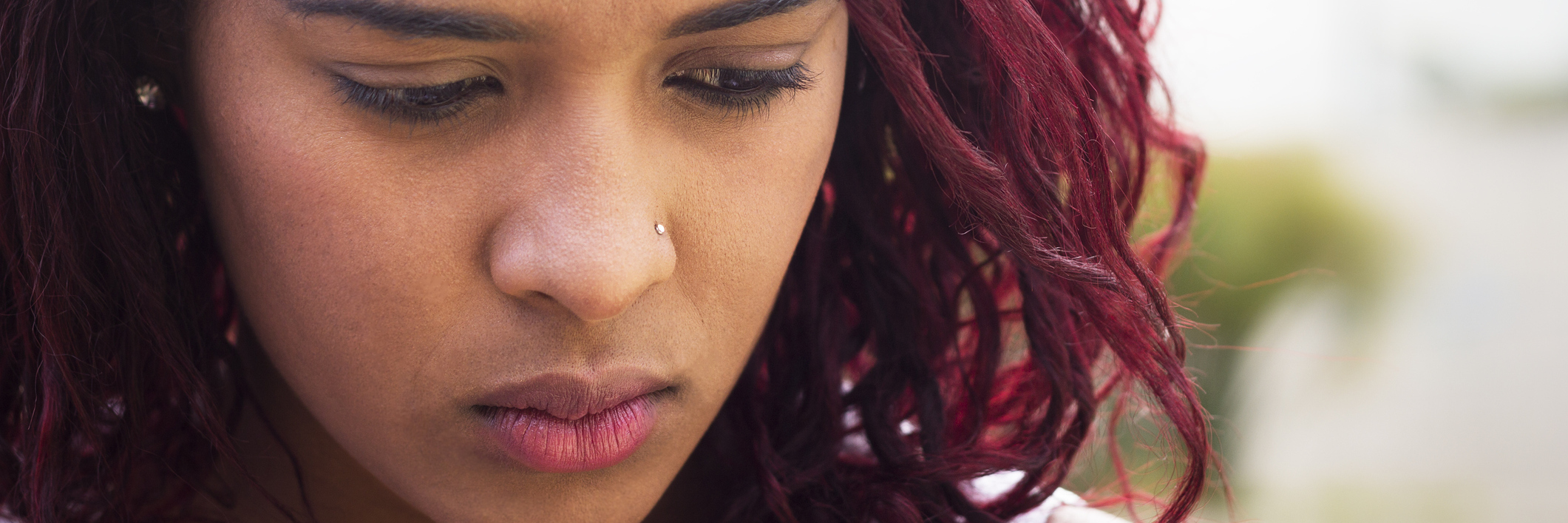 Depression Shouldn’t Be Treated as ‘Just Being Sad' Young black woman with sad expression looking down.