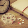 daily pills and alarm clock with diary in vintage color concept
