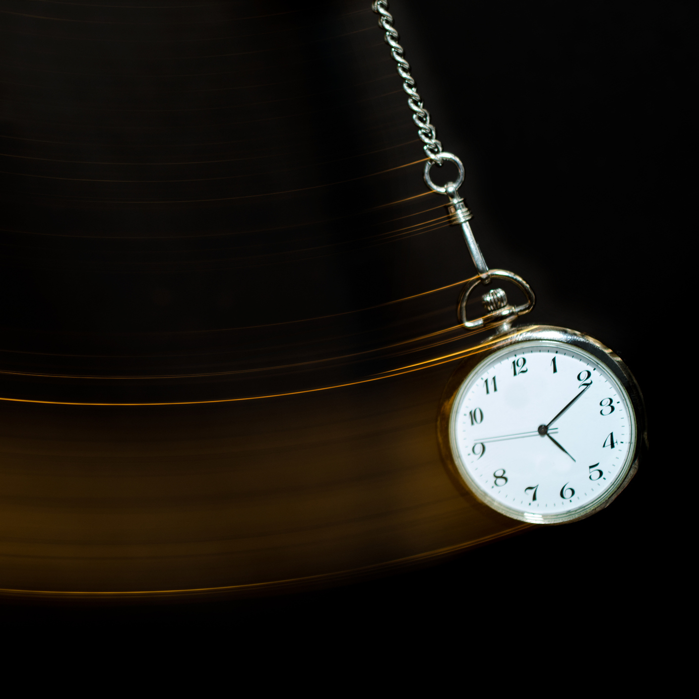 A pocket watch swinging in the air.