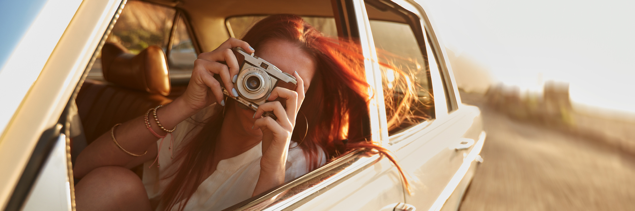 5 Tips for Taking Road Trips When You're Chronically Ill A woman taking a photo from the car.
