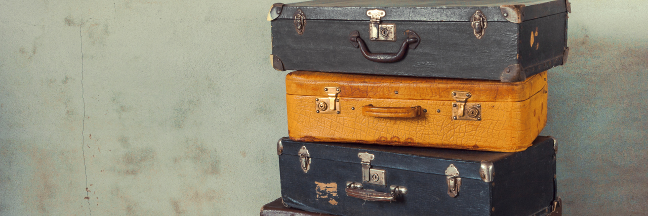 Why Owning My 'Baggage' Was So Important in My Mental Health Recovery Many old suitcases stand in an empty room