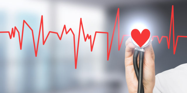 How Battling Depression Affects My Congenital Heart Defect hand listening to a red heartbeat with a stethoscope