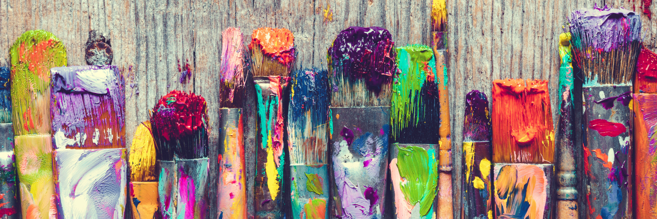 Why I Decorate My Hearing Aids and Cochlear Implants Row of artist paint brushes closeup on old wooden background.
