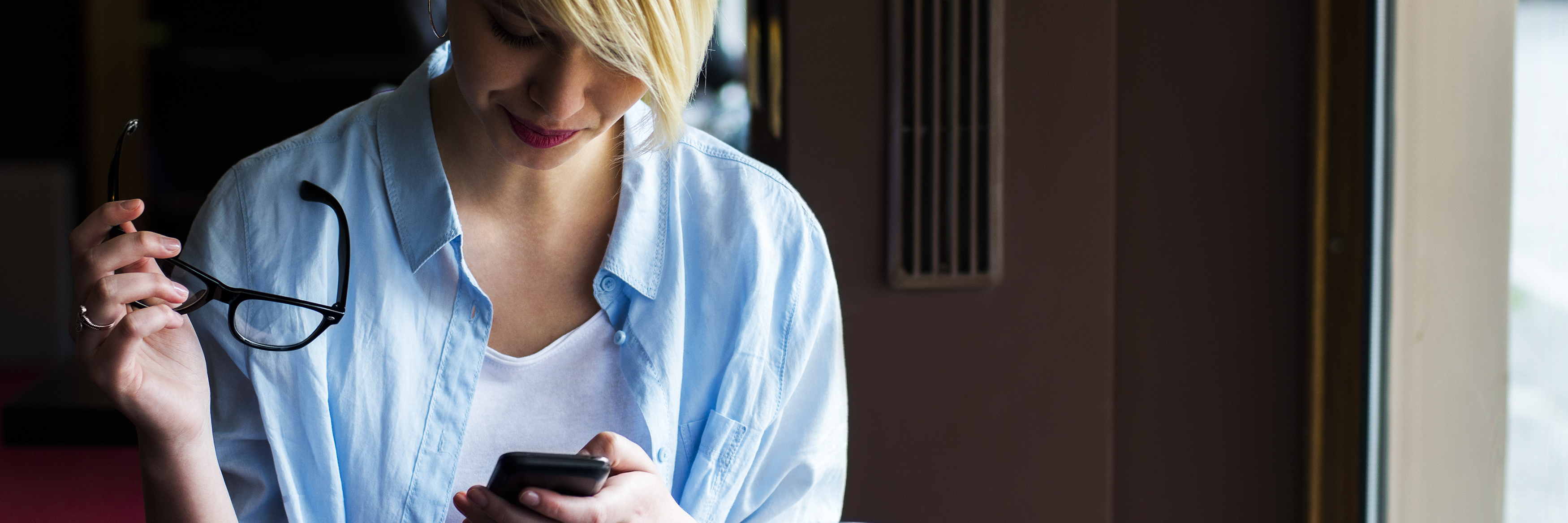 How Anxiety and Depression Affect Me on Social Media young woman in cafe checking smartphone with glasses in hand