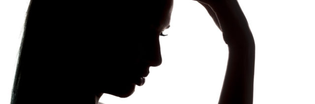 silhouette profile of a young woman touching her forehead on a white background