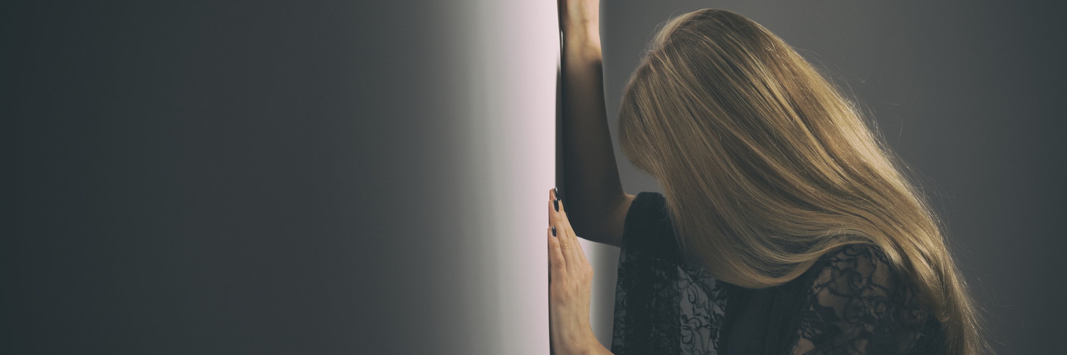 When I Hit 'the Wall' of Medical Testing Exhaustion A woman leaning against a wall, hear head looking down.