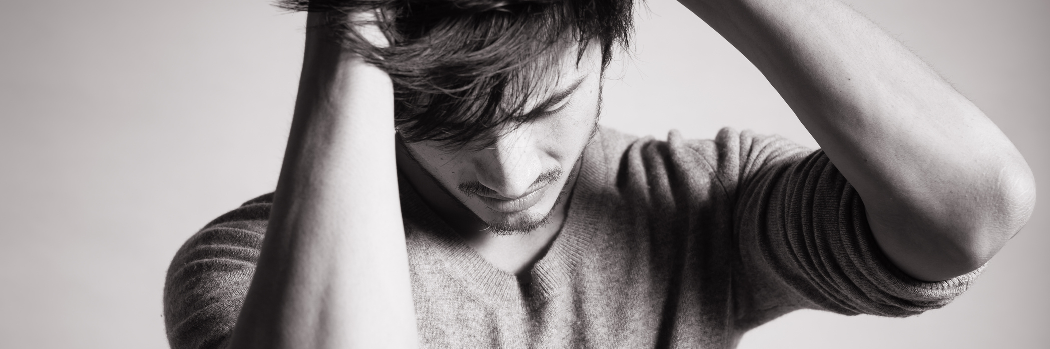 Why I Began Taking Medication for My Anxiety young man in black and white with hands in hair in despair