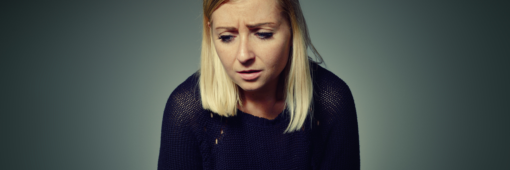 woman looking upset holding stomach in pain or sickness