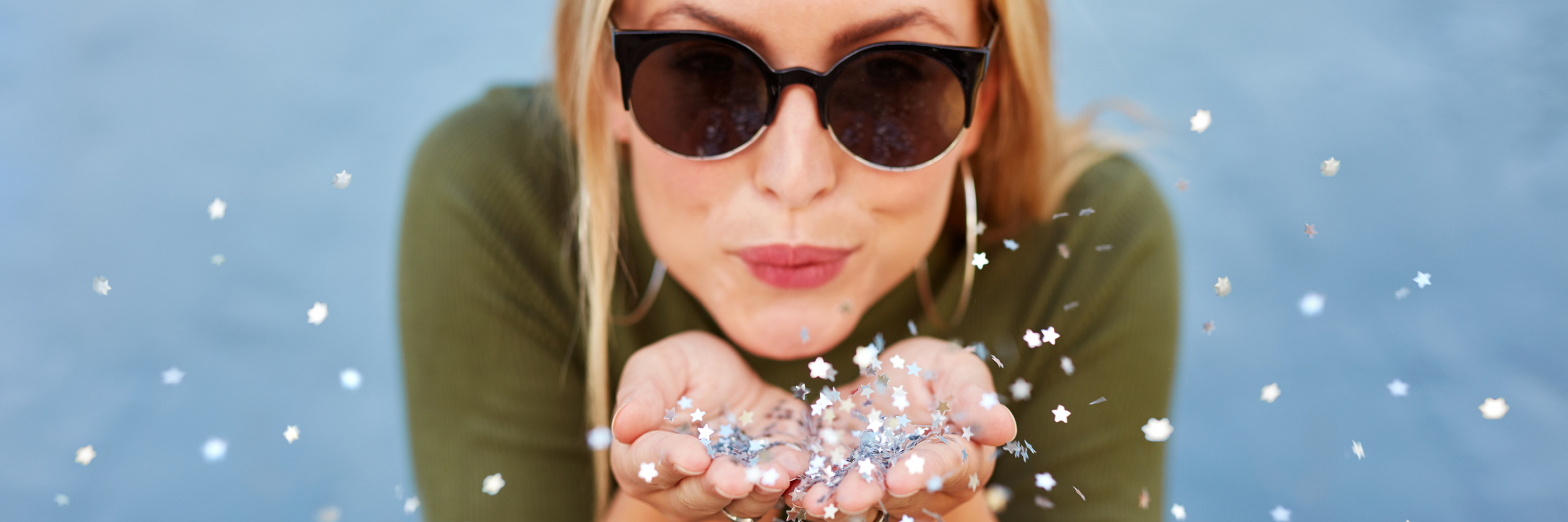 How I Found Reasons to Be Happy After My Diagnosis A happy woman wearing sunglasses, blowing glitter.