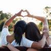 Mom and daughter forming a heart with their hands