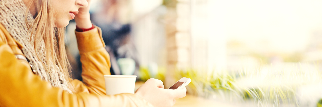 Choosing the Right Words When a Friend Has Anxiety young blonde woman with mobile phone in cafe looking worried