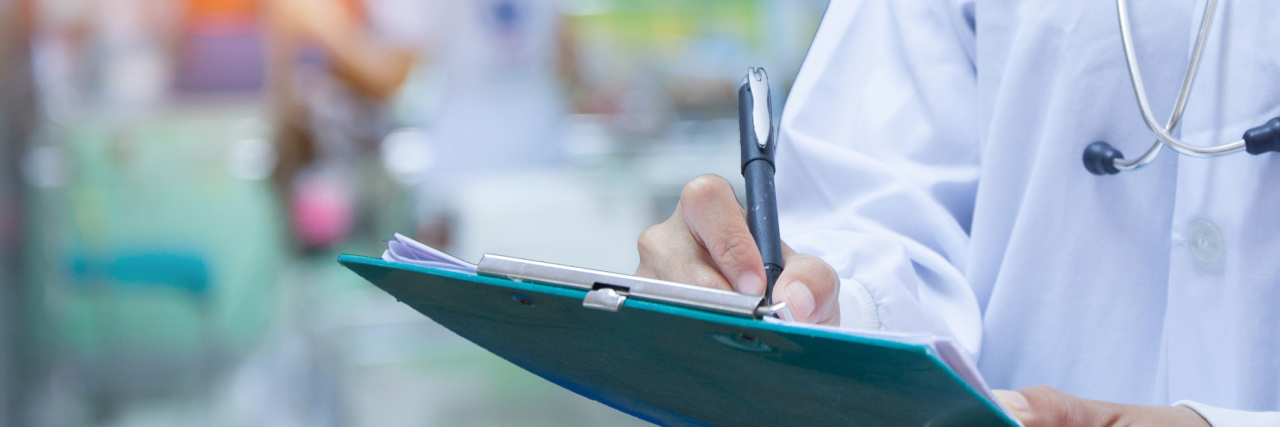 Doctor writing a medical prescription in hospital