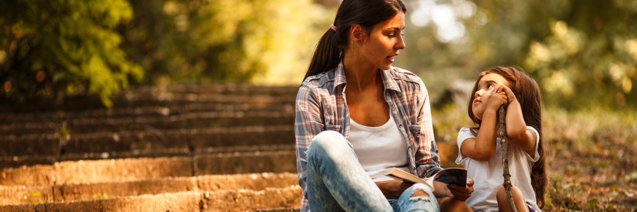 Why My Mental Illness Means I Can't Have Another Child mother and daughter talking in park with book