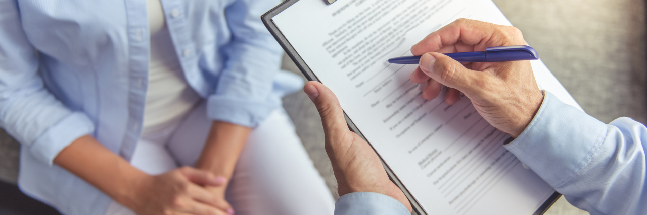 My Experience Going to a New Psychiatrist for Medication close image of woman at therapist or psychiatrist holding clipboard
