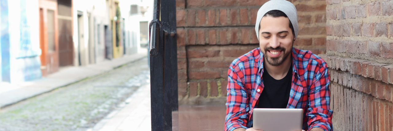 5 Tips to Boost Addiction Recovery Young latin man using a tablet at the street.