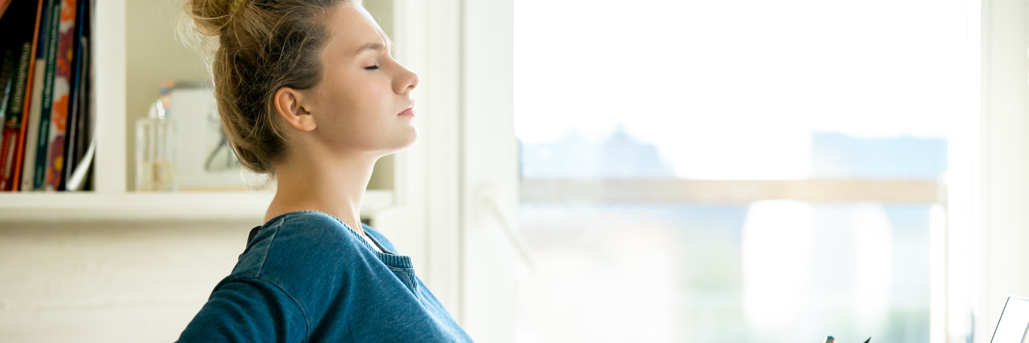 How to Cope With the Physical Effects of Anxiety young woman at desk with back pain