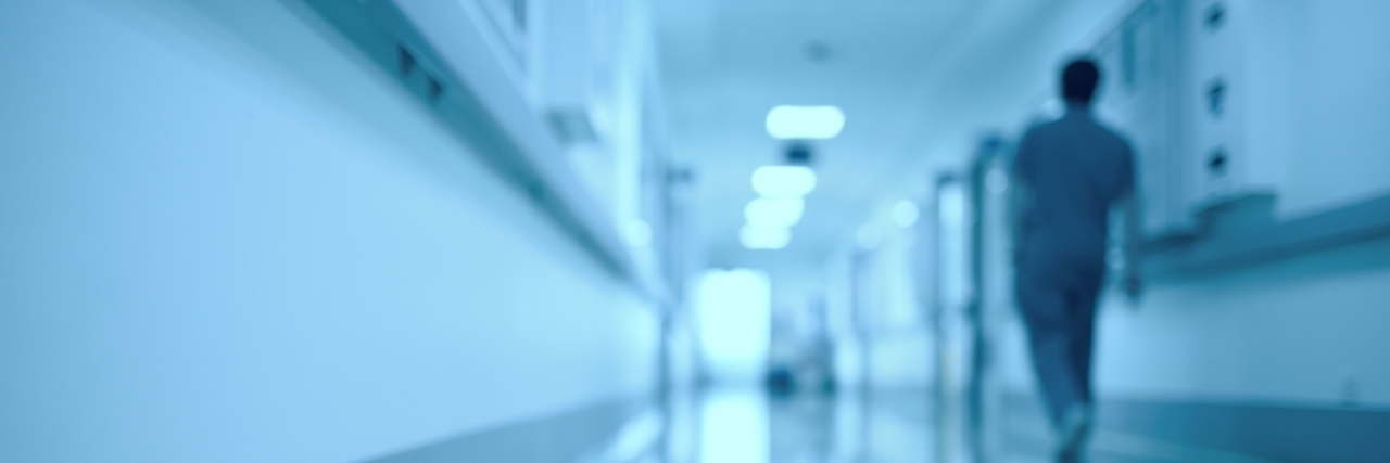 Why I Choose to Remember the Abuses Mental Patients Had to Go Through Blurred medical background. Moving human figure in the hospital corridor.