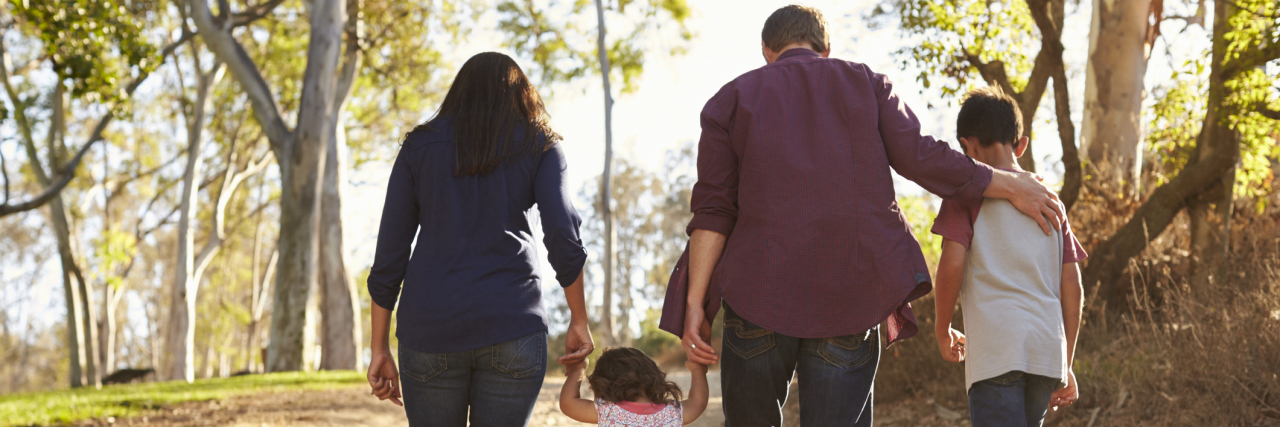 4 Ways to Teach Your Kids About Caring for Their Mental Health Mixed race family walking on rural path, close up back view