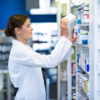 pharmacist putting medication on a shelf