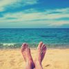 woman's feet relaxing on beach