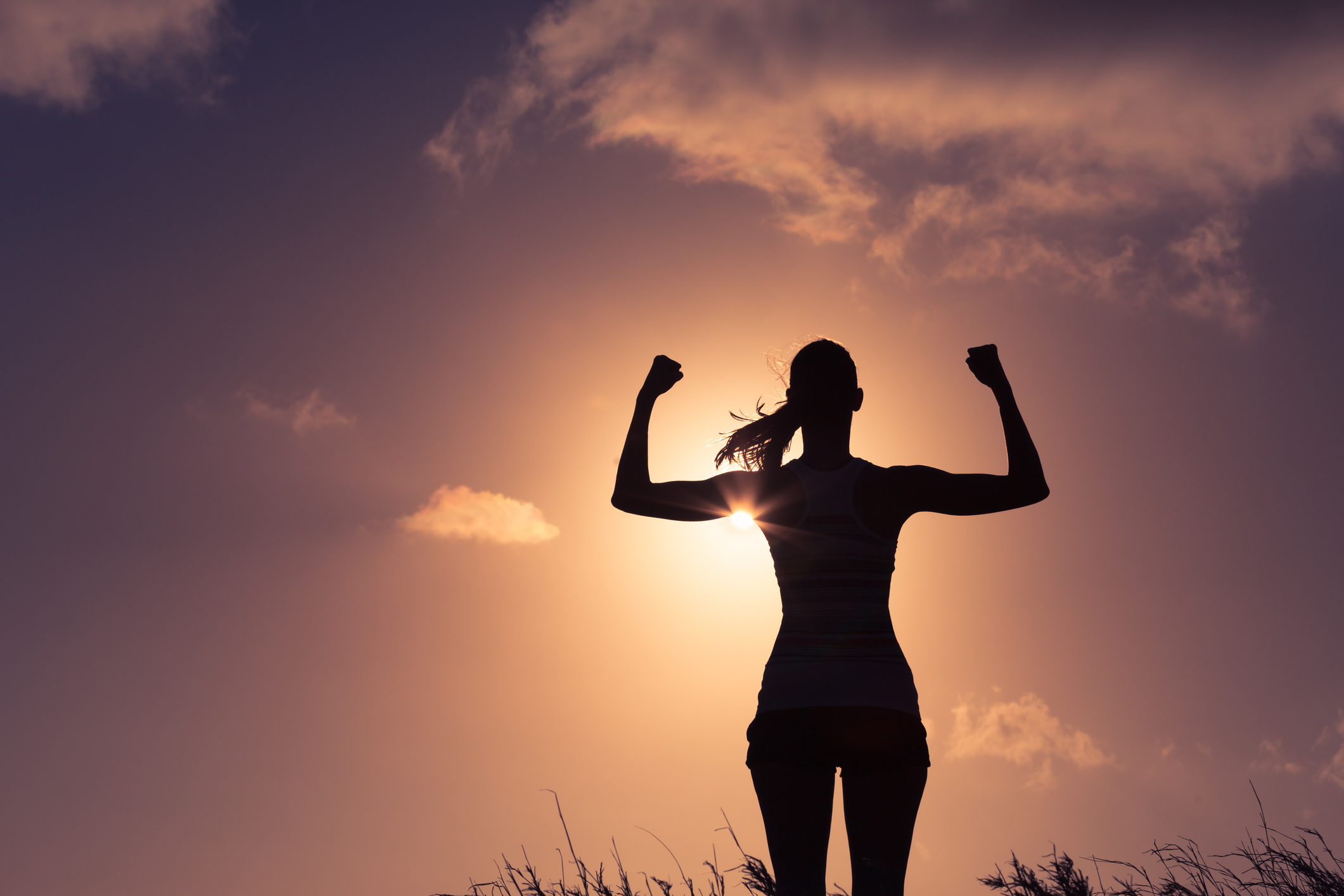 woman showing strength in sunset