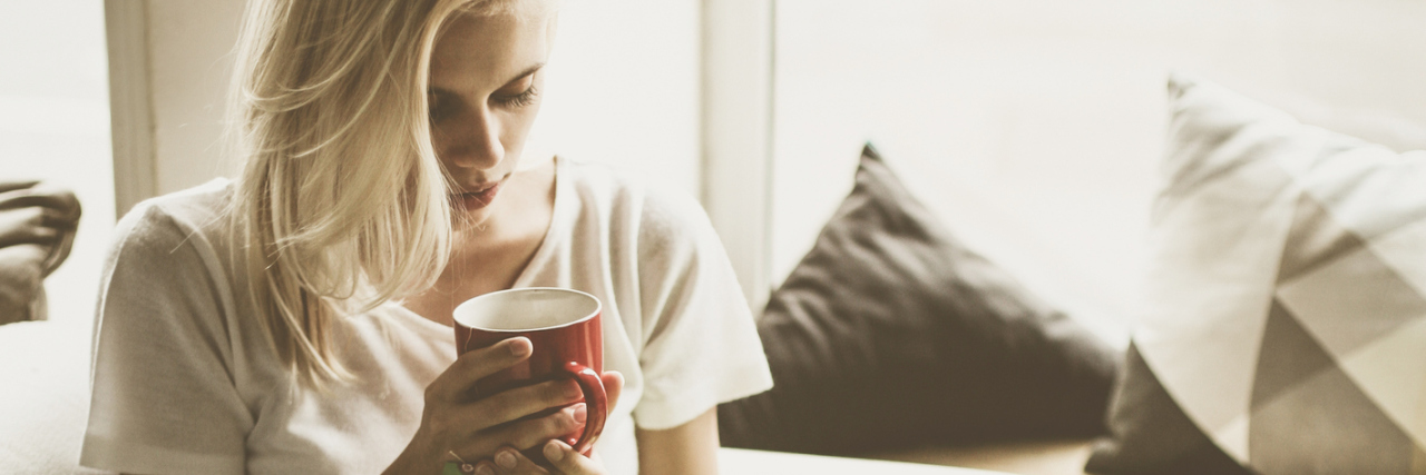 Why I Now Need Physical Therapy Because of My Depression woman resting on couch holding cup of coffee
