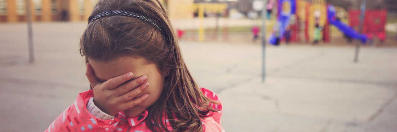 Letter to Kids Who Bullied Me Because of My Autism Sad girl in the school playground.