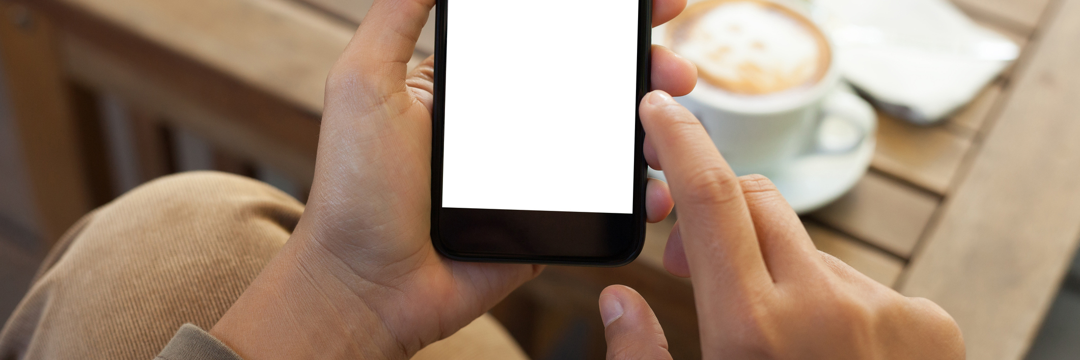 How a Facebook 'Like,' 'Love' or 'Share' Could Impact Mental Health close-up hand holding phone mobile blank screen and finger touching in coffee shop