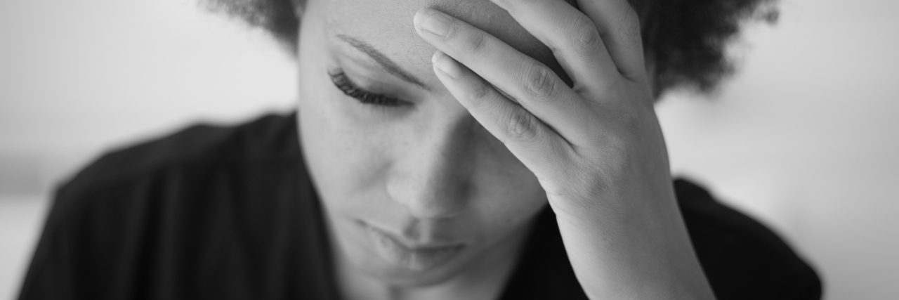 Tips for Managing Brain Fog With Fibromyalgia black and white photo of a woman holding her head