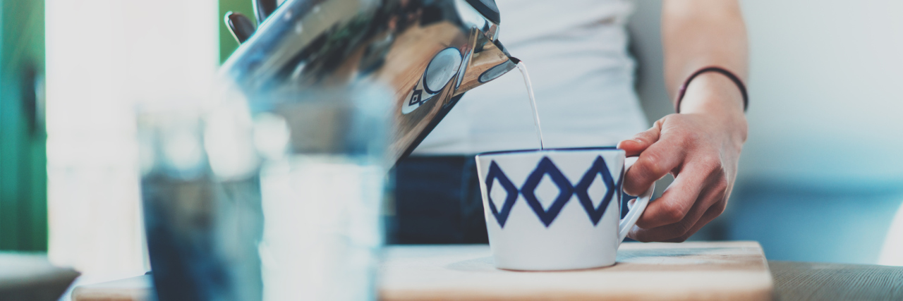 My OCD Makes Even Simple Tasks Exhausting woman making tea in kitchen with blur effect
