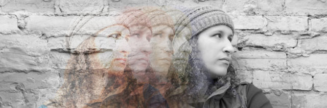 Multiple exposures of young woman standing with crossed arms against urban wall looking away, images from color fading