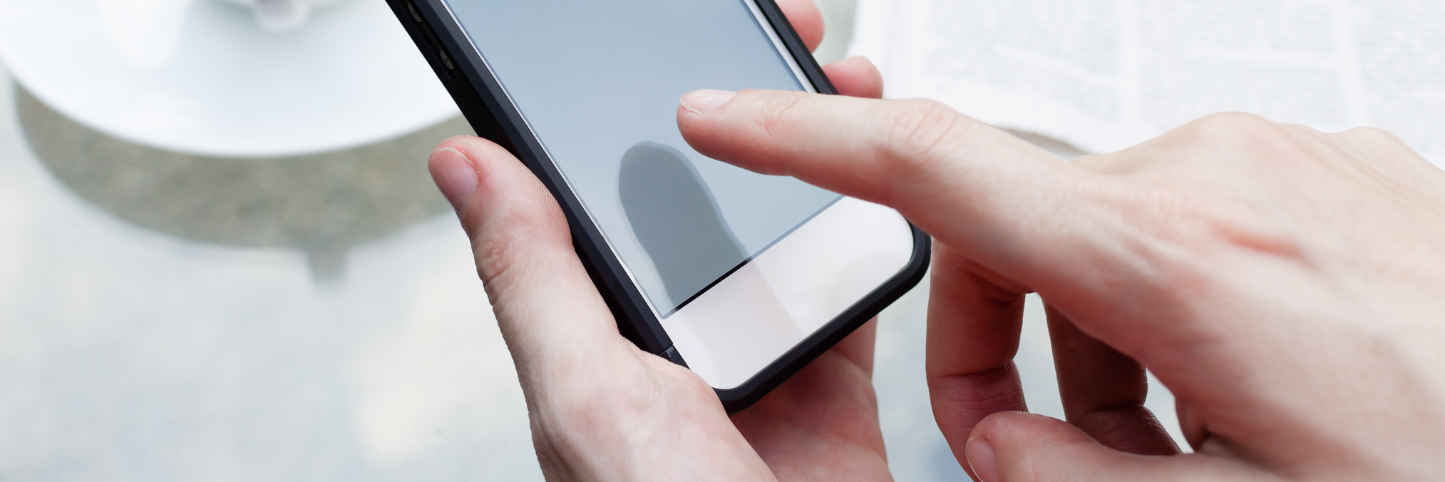 Close up image of woman using her smart phone while having a breakfast.