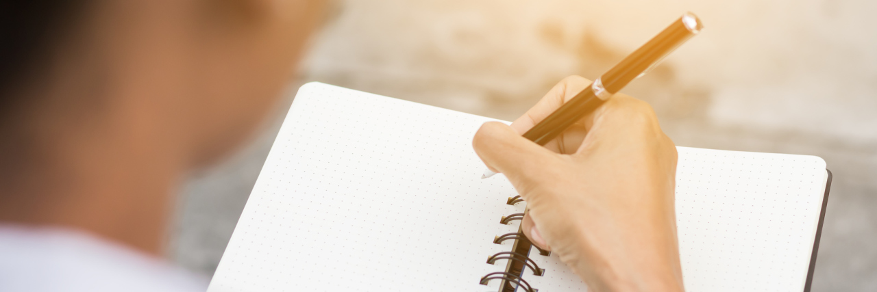 A Letter to Pre-Breast Cancer Me About What I Wish I Knew A woman writing somethings in a notebook.