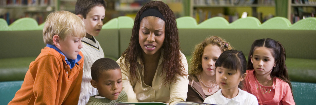 Why I Love Being a Special Education Teacher Teacher reading to students in the library.