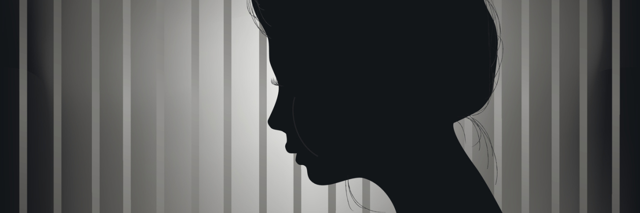 Living in the 'Grey Area' of Having an Undiagnosed Chronic Illness silhouette of a woman standing in front of a grey striped wall