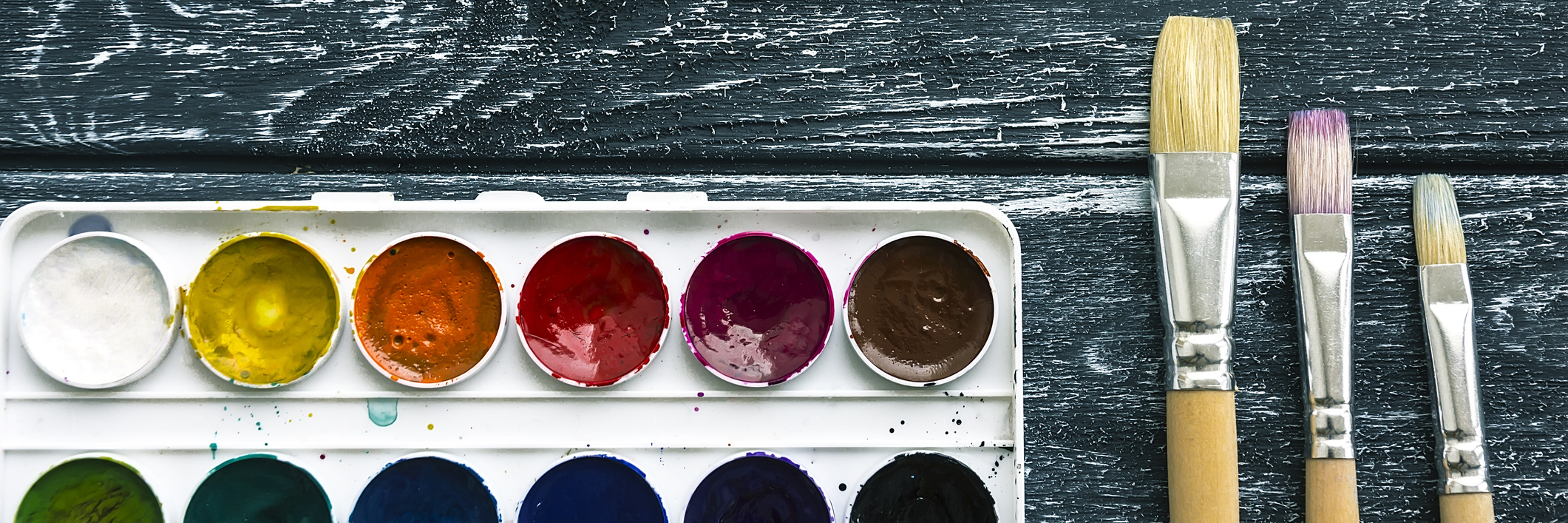 Why I'm Asking You to Paint Rocks for Gastroparesis Awareness Pain and paint brushes, against a wooded table.