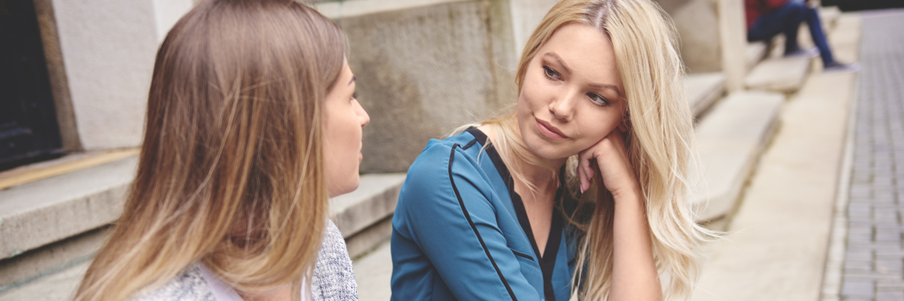 Why You Shouldn't Give Medical Advice to a Lupus Patient two friends talking and sitting on steps outside