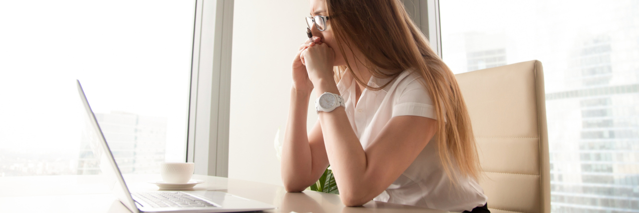 How Hypomania Is Helping Me Deal With a Bad Situation worried businesswoman at laptop wearing glasses
