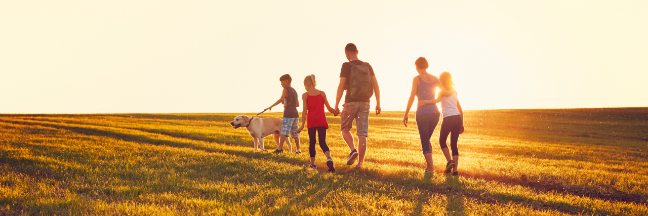 Autism in the Family: Generationally Neurodiverse Family with dog in a field.