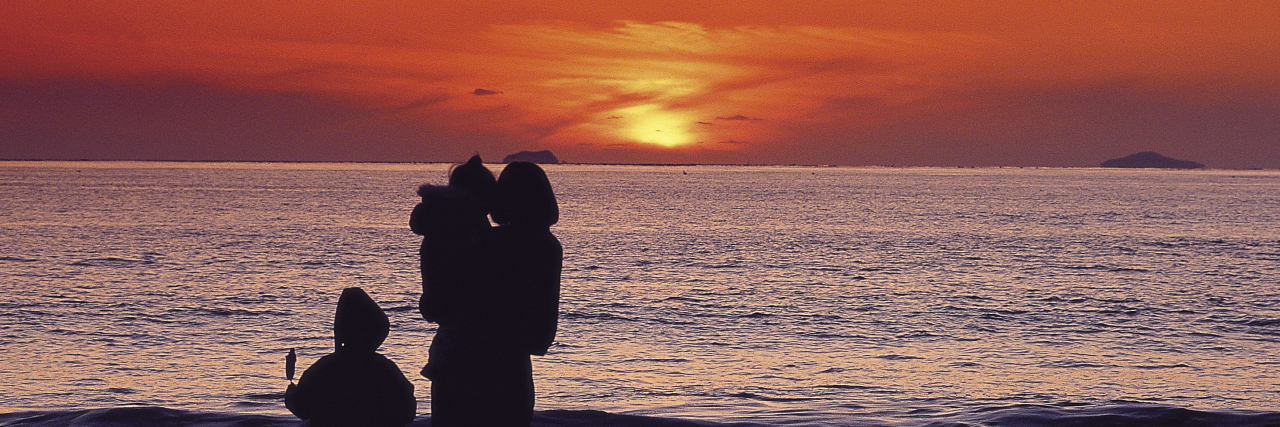 My Autistic Children Helped Me Accept My Own Autism Mother with children on the beach at sunset.