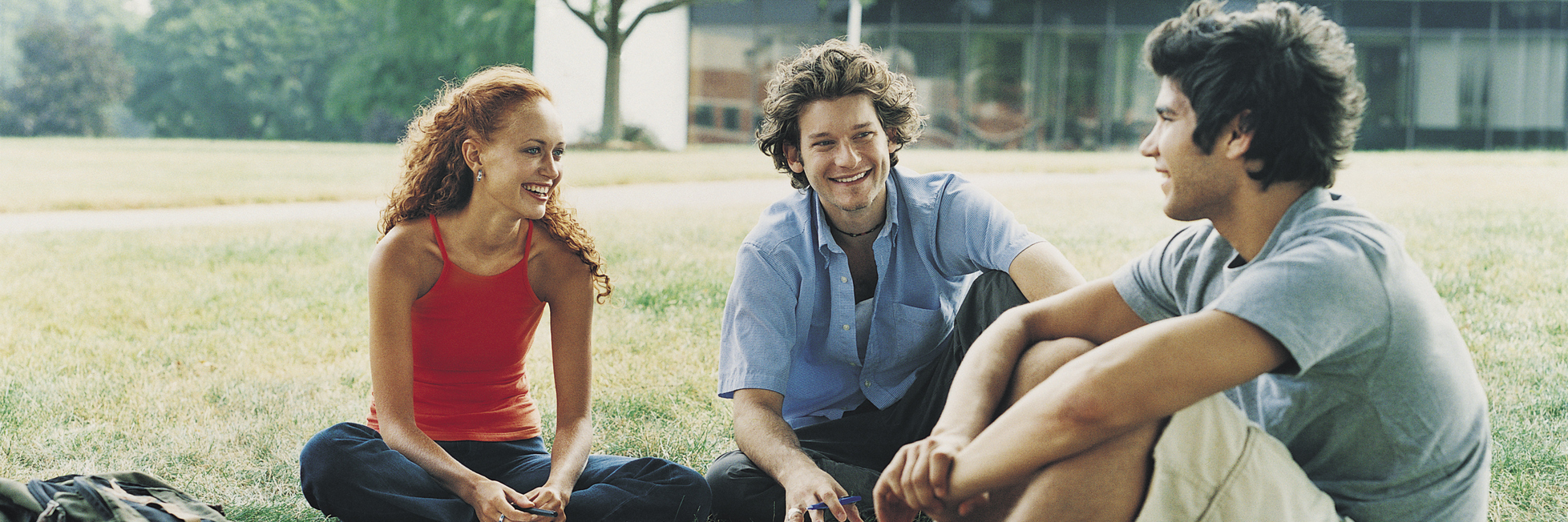 Tips for Dealing With Chronic Pain in College three students sitting outdoors on campus with their school work