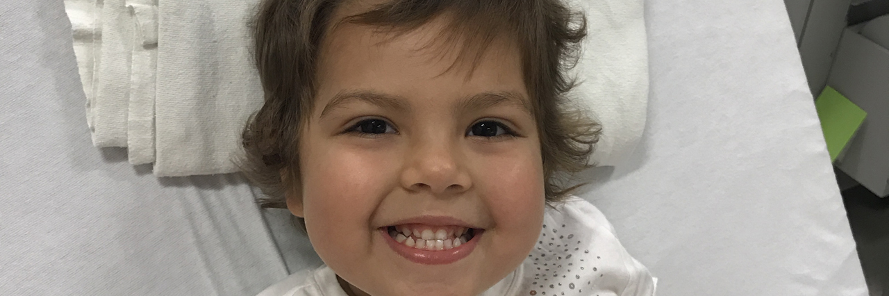 The Reality of Sending My Child With Leukemia to School Young Girl with Cancer Smiling in Hospital Bed