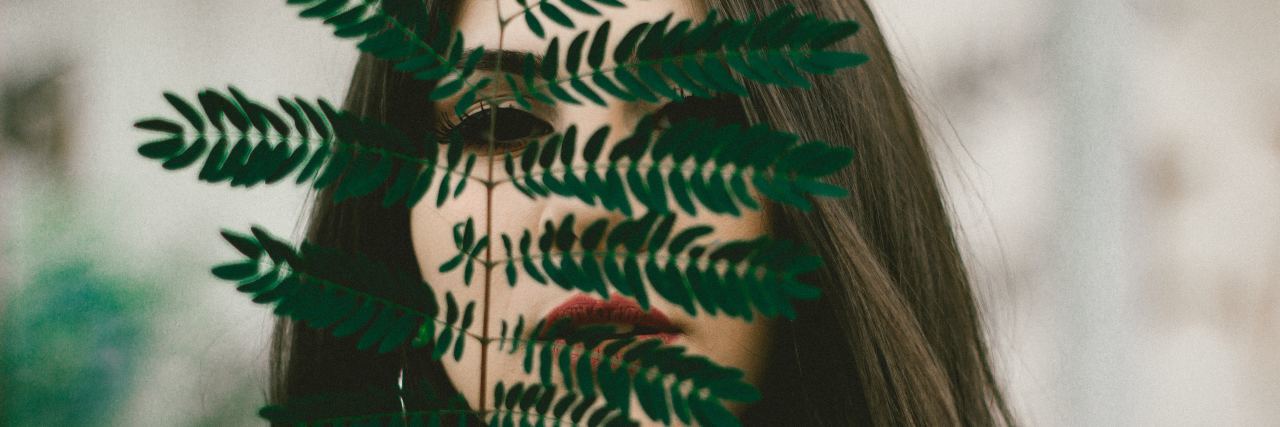 11 Signs That Might Mean Your 'Shyness' Is Actually Social Anxiety woman behind leaf