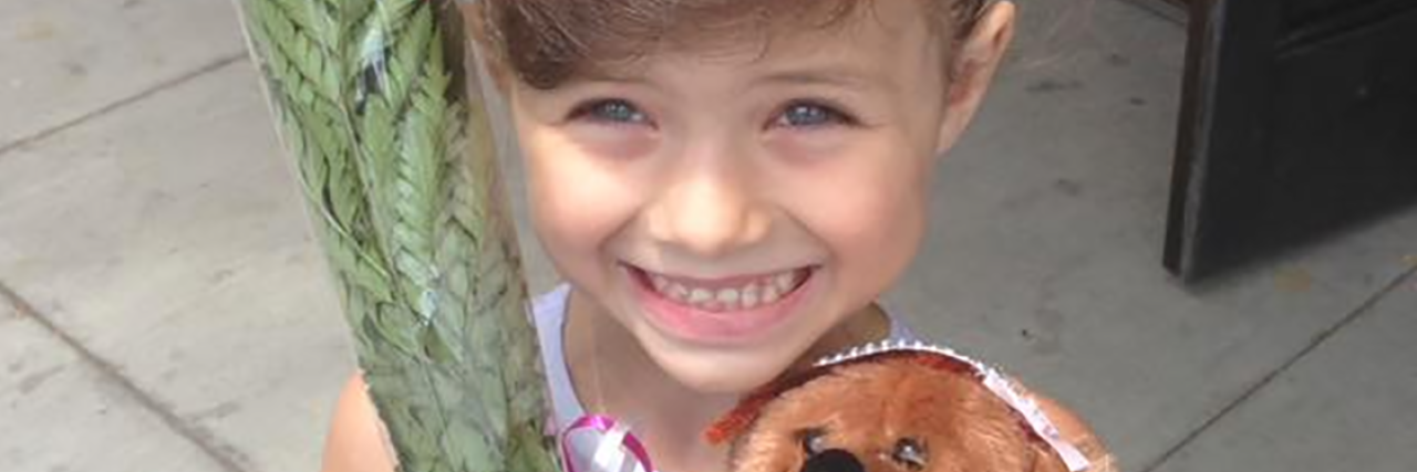 Anxiety Left My Seat Empty at My Daughter's Ballet Recital little ballerina giirl holding flowers and teddy bear smiling at camera