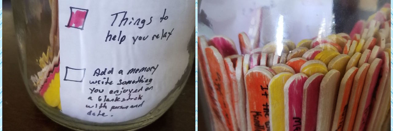 A jar with colorful popsicle sticks in it