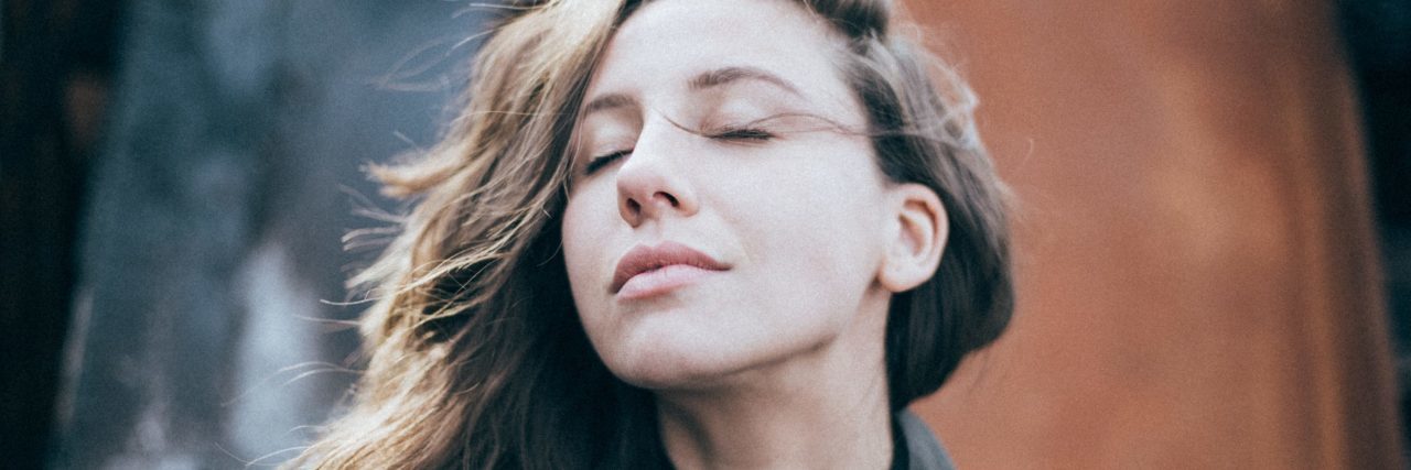 How This Stigmatized Psychiatric Treatment Saved My Life young woman with brown hair looking content