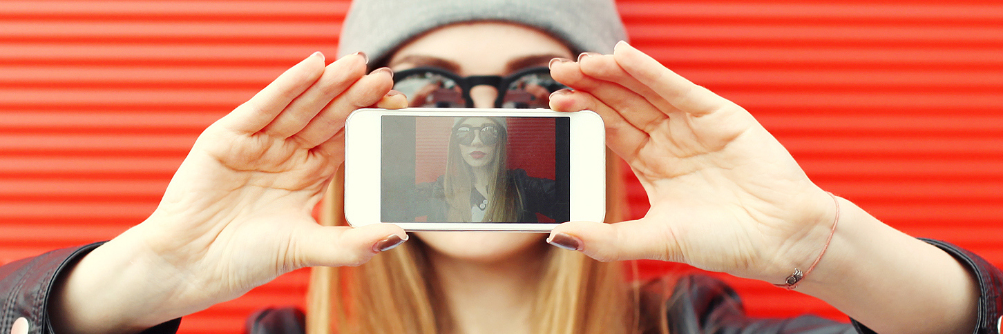 Posting Photos Online With Crohn's Disease and Weight Loss girl taking photo of herself on smartphone