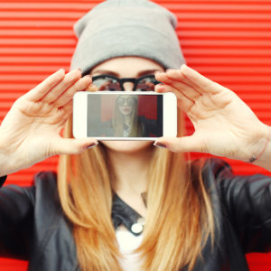 girl taking photo of herself on smartphone